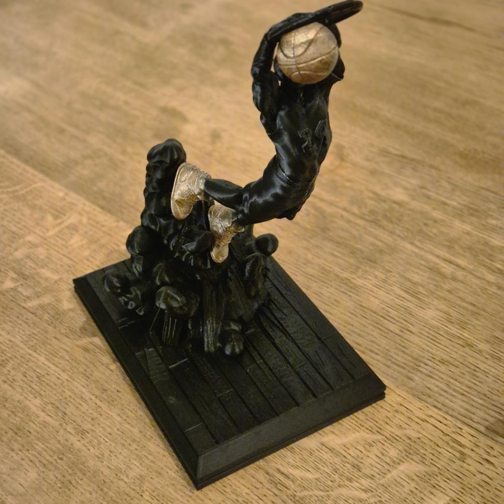 Basketballspieler macht Slam Dunks im Korb – Dynamische Sportstatue